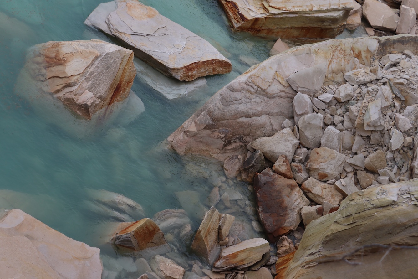 Photo looking down onto rocky lakeshore from cliffs